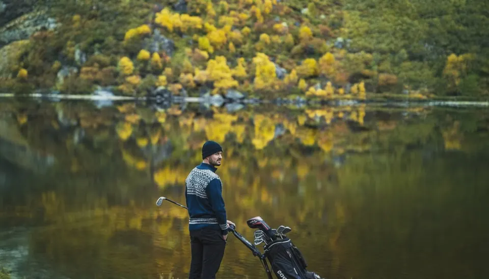 Golfer in KAMA knitwear beside a still lake